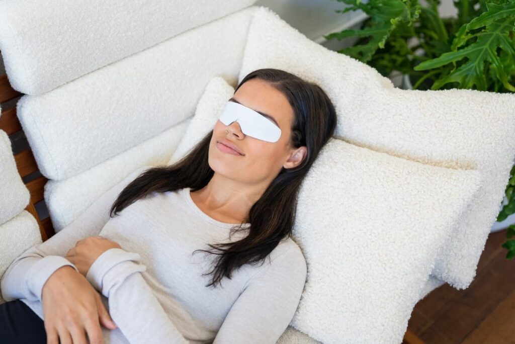 woman resting with cold compress on eyes